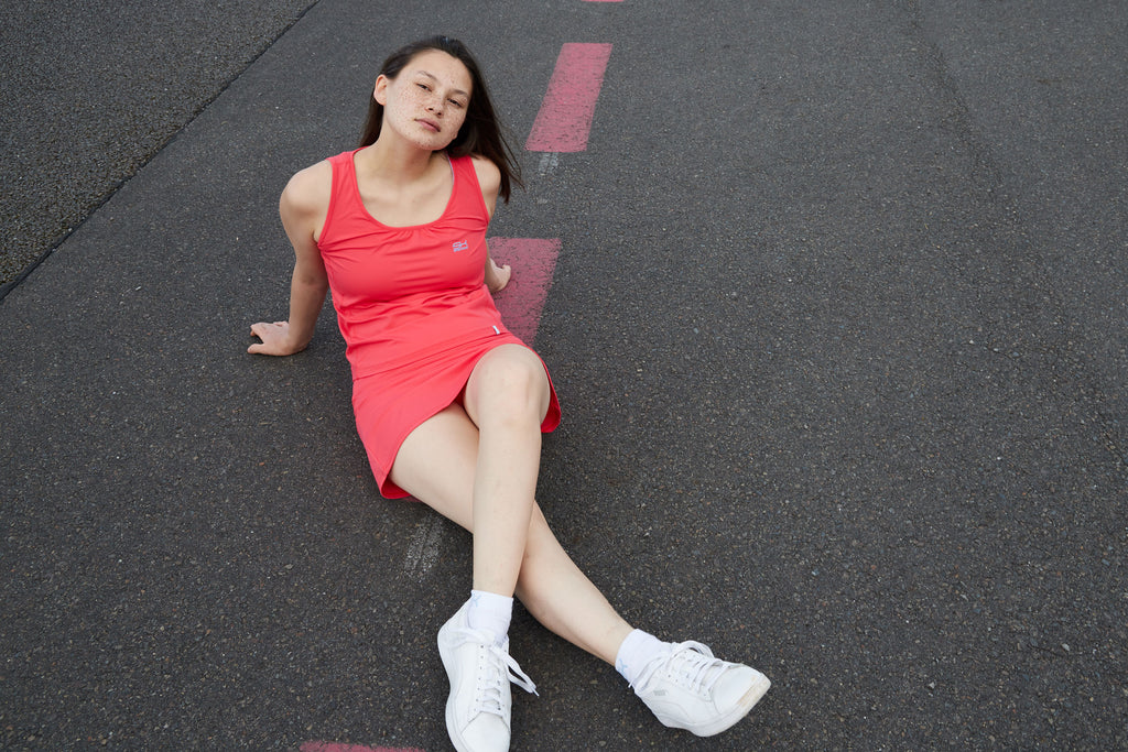 Sportbekleidung in Pfirsich-Rot bestehend aus Loose-Fit Tanktop und Sportrock in Pfirsichfarben