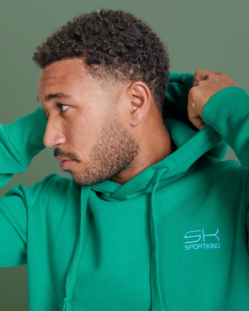 Mann im smaragd gruenen SPORTKIND Hoodie